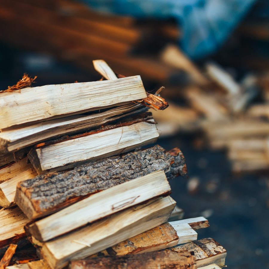 A pile of stacked firewood, prepared for heating the house. Gathering fire wood for winter or